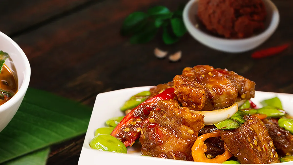 หมูสามชั้นผัดสะตอพริกแดงของร้านบ้านไอซ์บนจานขาว