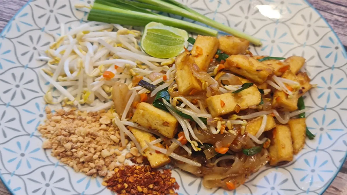 ผัดไทยวีแกนใส่เต้าหู้ของเมย์ เวจจี้ โฮม บนจานลายคราม
