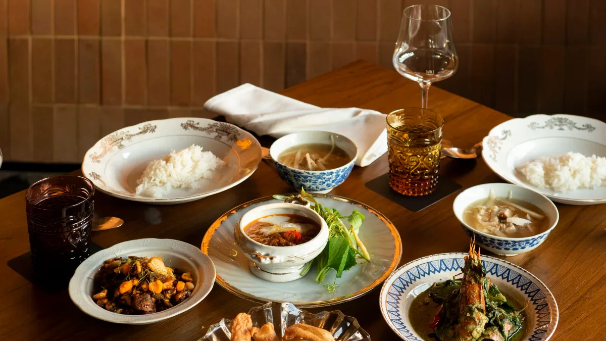 สำรับอาหารไทยที่ร้านอักษร มีแกงเขียวหวานกุ้งแม่น้ำ น้ำพริก ต้มจืด และข้าวสวยบนโต๊ะไม้