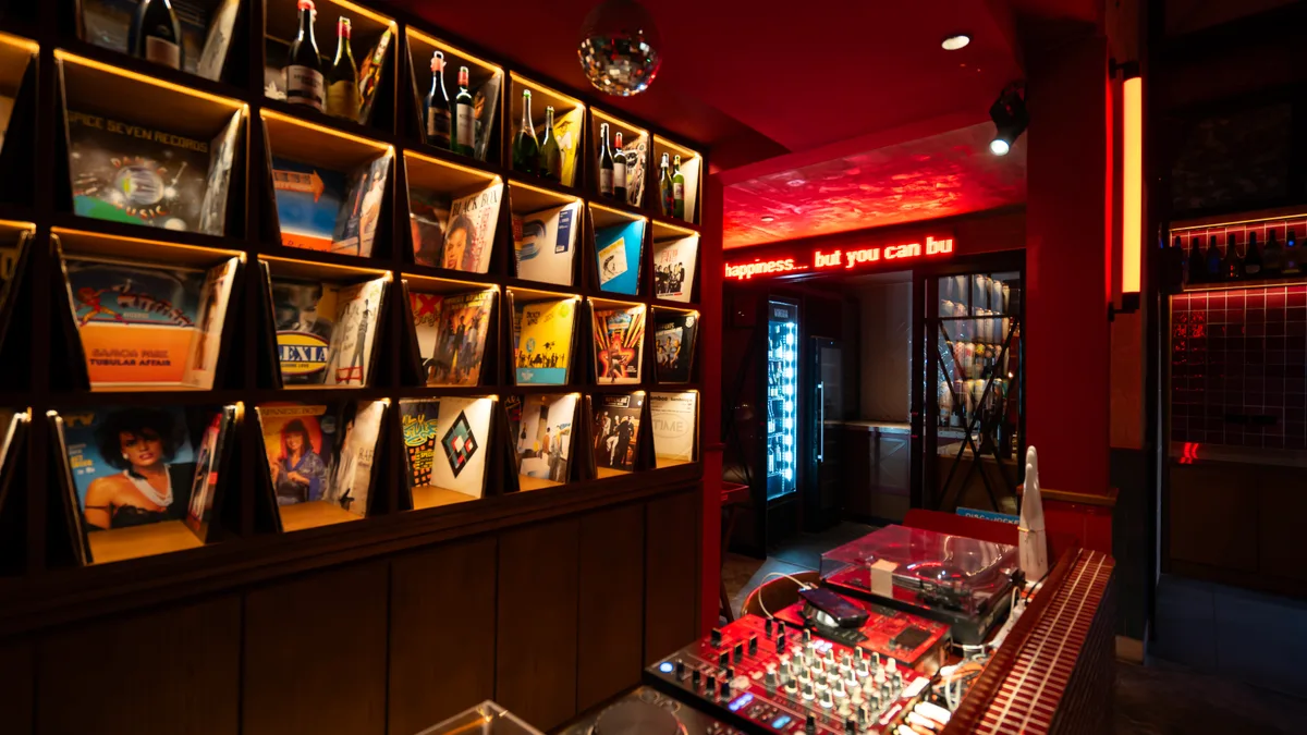 ผนังแผ่นเสียงและบาร์แสงไฟสีแดงในร้าน Capricci