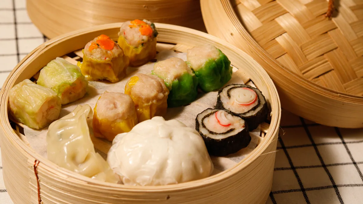 ขนมจีบ เกี๊ยว และติ่มซำหลายอย่างในเข่งไม้ไผ่ของโชคดีติ่มซำ