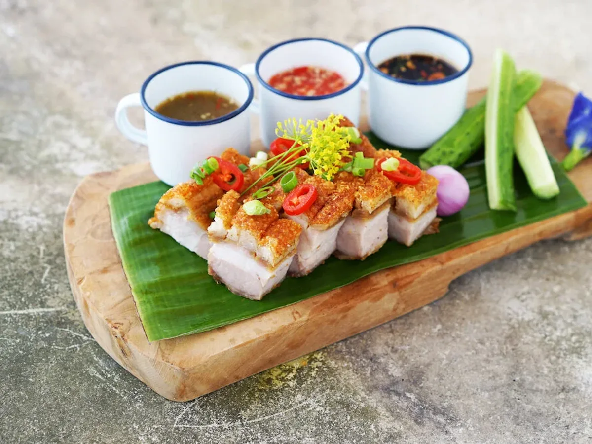 หมูสามชั้นทอดกรอบบนเขียงไม้กับน้ำจิ้มสามถ้วย