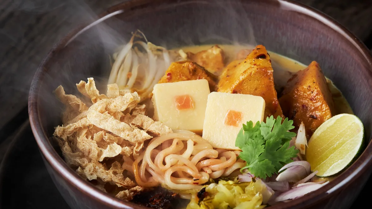 ก๋วยเตี๋ยววีแกนในชามดำกับเต้าหู้ ปอเปี๊ยะทอด และผักชีที่ร้านเมอร์ซี่ รีพับลิก
