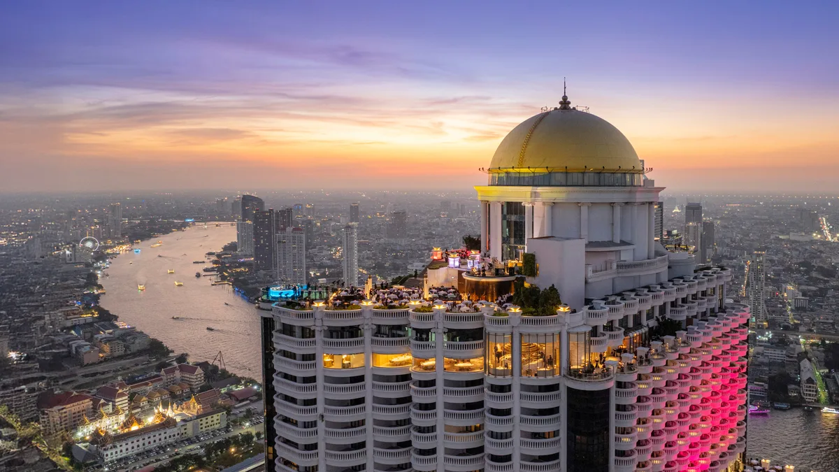 โดมสีทองของเลอบัวและสกายบาร์เหนือโค้งแม่น้ำเจ้าพระยายามพลบค่ำ